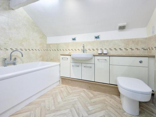 a bathroom with a sink and a tub and a toilet at 2 Bed in Buttermere SZ588 in Buttermere