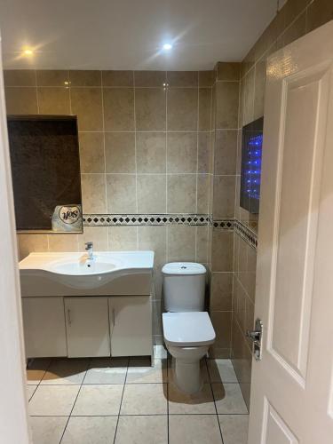 a bathroom with a toilet and a sink at High Street Lodge in Clowne