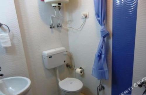a small bathroom with a toilet and a sink at Hotel Mehar Srinagar in Srinagar