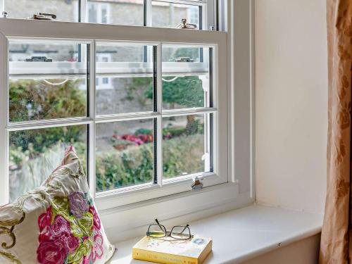 una ventana con un libro y gafas en un alféizar de la ventana en 3 Bed in Bridport 85255 en Puncknowle