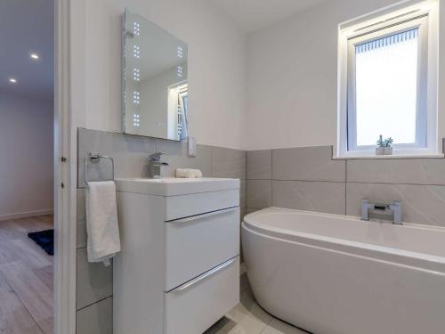 a white bathroom with a tub and a sink at 1 Bed in Sennen 85330 in St. Just