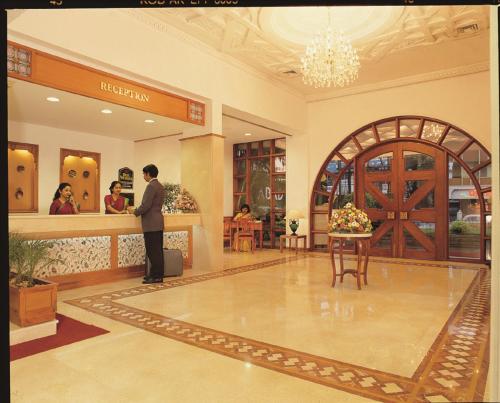 a man standing at a counter in a store at Hotel Abad Plaza in Cochin