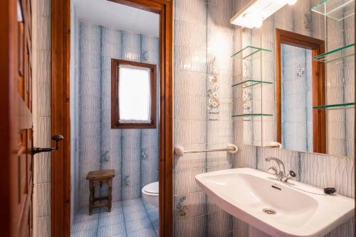 a bathroom with a sink and a toilet and a mirror at Villa Sabine - PlusHolidays in Calpe