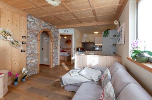 een woonkamer met een bank en een bakstenen muur bij Chalet Roberta in Valdidentro