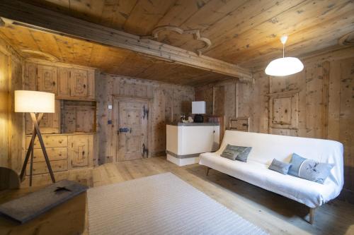 sala de estar con sofá blanco y paredes de madera en Chasa Punt, en Scuol