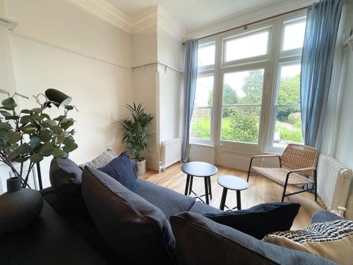 a living room with a blue couch and a large window at Centrally located studio flat sleeps 4 in Ealing