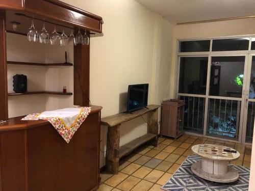 Zimmer mit einer Küche mit einem Tisch und einem TV in der Unterkunft Quarto privado em apartamento. in Vitória