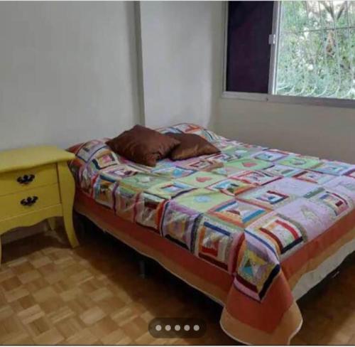 Bett in einem Zimmer mit einem Nachttisch und einem 6-dx-dx-Bett. in der Unterkunft Quarto privado em apartamento. in Vitória
