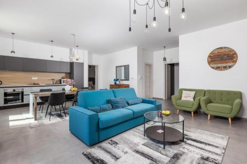 a living room with a blue couch and a table at Molo Longo - Downtown Apartments in Rijeka