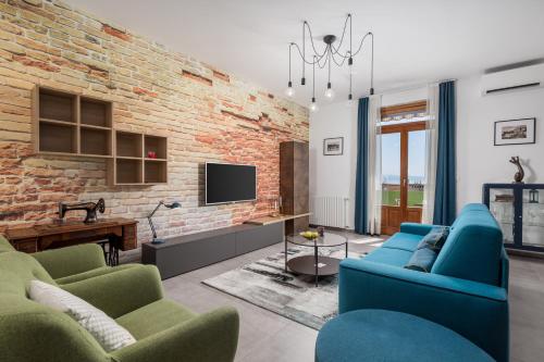 a living room with blue couches and a brick wall at Molo Longo - Downtown Apartments in Rijeka