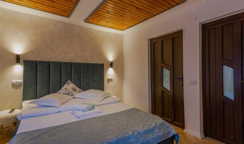 a bedroom with a large bed with a green headboard at Complex Turistic Luminita in Moieciu de Sus