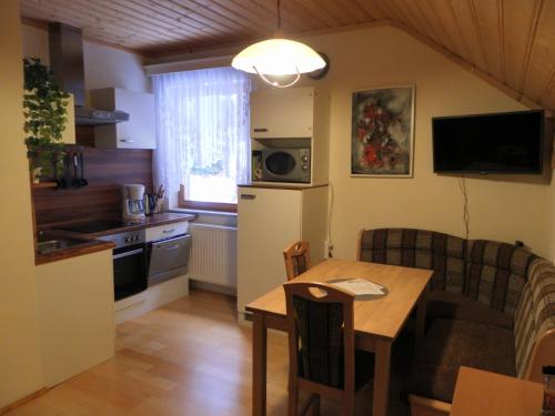 eine Küche und ein Esszimmer mit einem Tisch und einem Sofa in der Unterkunft Apartment zum Wasserfall in Krakaudorf