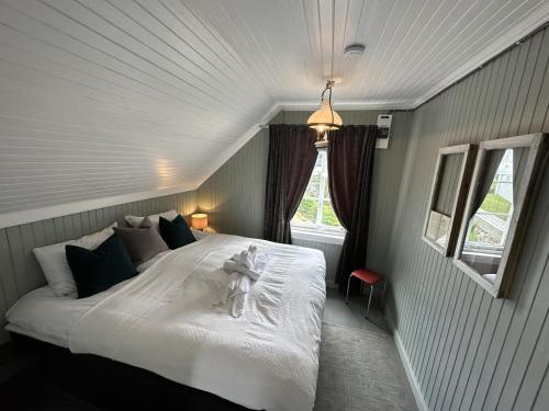 a bedroom with a white bed with a teddy bear on it at #Reinehuset - Amazing view! in Reine