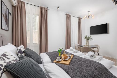 a living room with a bed and a table at Molo Longo - Downtown Apartments in Rijeka