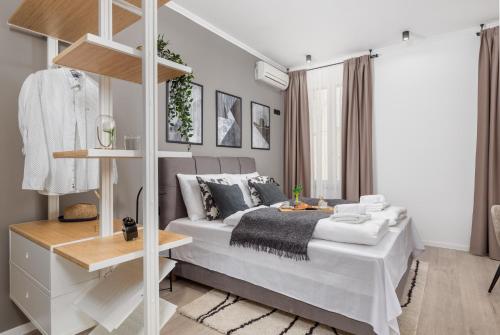a bedroom with a large white bed and a table at Molo Longo - Downtown Apartments in Rijeka