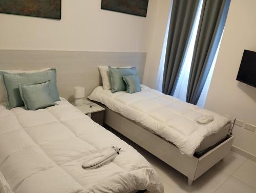 two beds sitting next to each other in a room at Pearl Apartments in Sliema