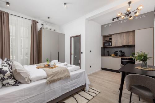 a bedroom with a bed and a table and a kitchen at Molo Longo - Downtown Apartments in Rijeka