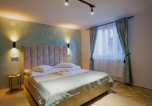 a bedroom with a large bed and a window at Complex Turistic Luminita in Moieciu de Sus