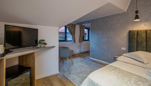 a bedroom with a bed and a flat screen tv at Complex Turistic Luminita in Moieciu de Sus