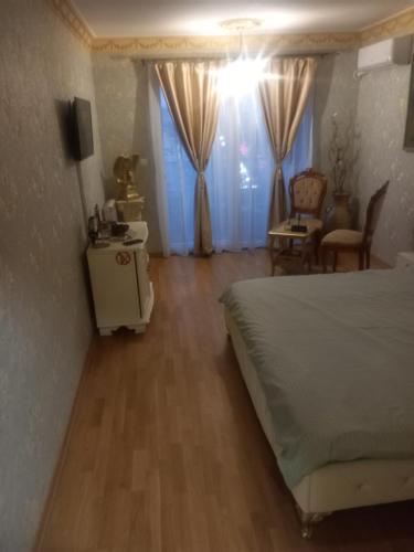 um quarto com uma cama, uma mesa e uma cadeira em Gold apartmants em Skopje