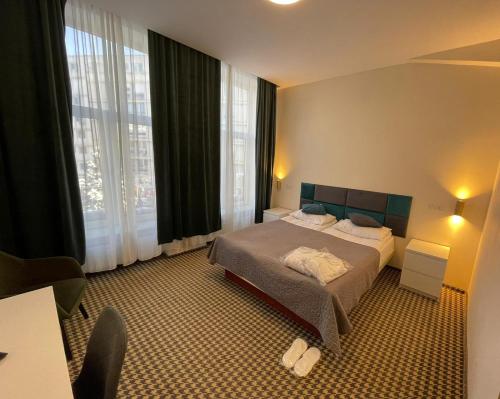 a hotel room with a bed and a large window at Hotel Astoria City Center in Iaşi