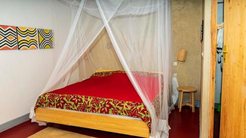 a bed with a canopy in a room at Isange Paradise Resort in Ruhengeri