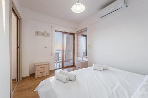 um quarto branco com 2 camas brancas e uma janela em Blue Heaven Beachfront em Durrës
