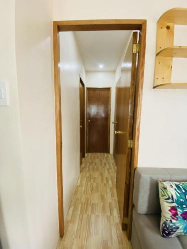 a hallway with a door and a couch in a room at Birbeck Lodge in Bulusan
