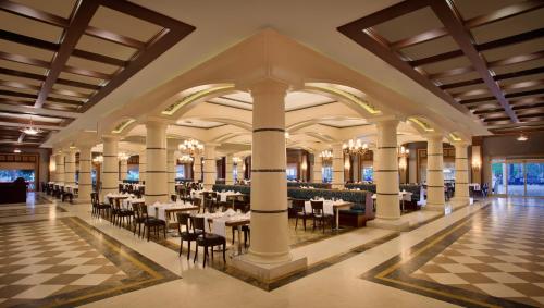 a restaurant with tables and chairs in a building at Paloma Grida in Belek