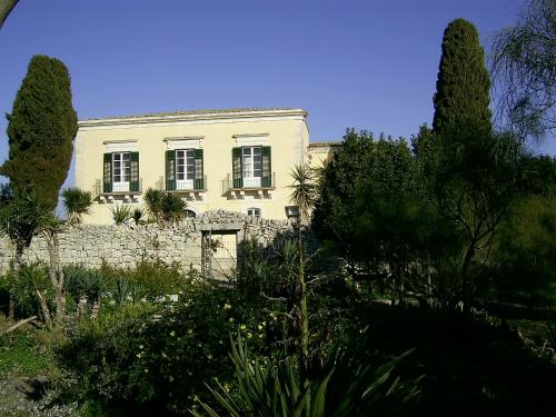 een wit huis met bomen ervoor bij Agriturismo Baglio Calanchi in Modica