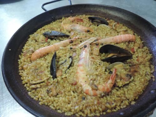 a pan filled with rice with shrimp and seafood at Hotel Mas Prades in Deltebre