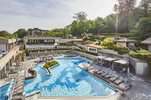 a large swimming pool with chairs and a slide at Studio - Thermes de Mondorf in Mondorf-les-Bains
