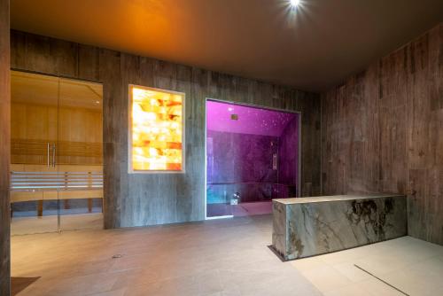 Habitación con banco de piedra y pared púrpura. en Hotel Munsch Restaurant & Wellness, Colmar Nord - Haut-Koenigsbourg en Saint-Hippolyte