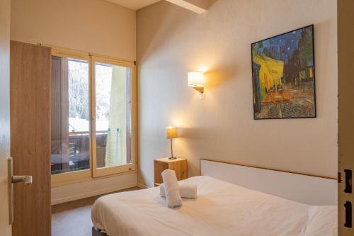 une chambre avec un lit blanc et une fenêtre dans l'établissement Apartment Lognan 6 Centre Chamonix Mont Blanc, à Chamonix-Mont-Blanc