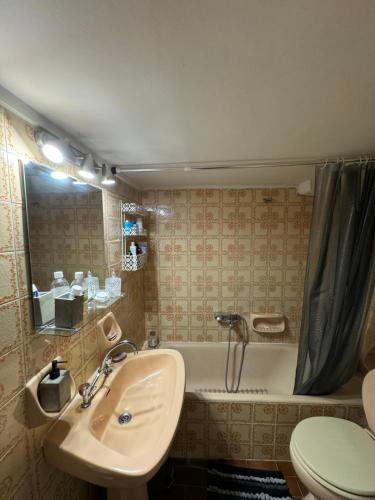 a bathroom with a sink and a tub and a toilet at Apollo Apartment Athens/Airport in Spata