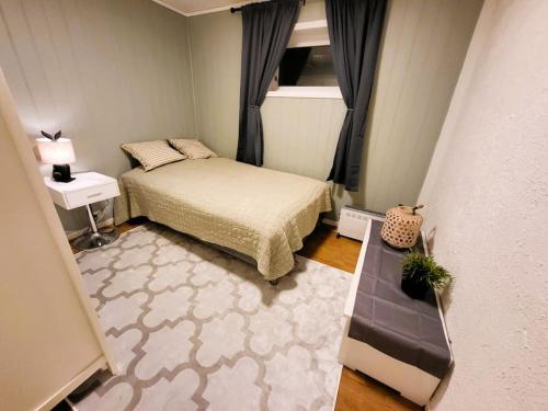 Dormitorio pequeño con cama y mesa en Ksu Nordlandet leiligheten, en Kristiansund