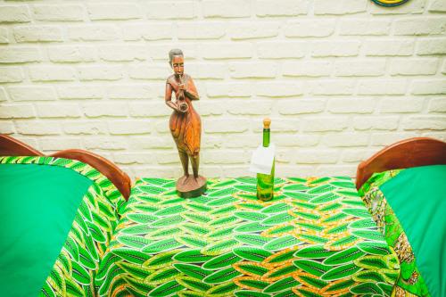 a table with a statue of a woman playing aviolinet at Isange Paradise Resort in Ruhengeri