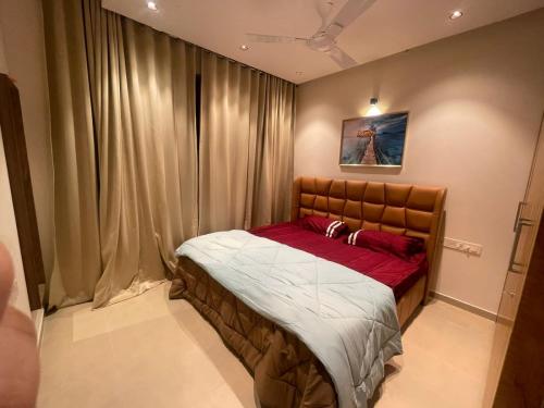 1 dormitorio con 1 cama en una habitación con cortinas en Hobbit - A sophisticated 2 bhk In Bharathiya city en Bangalore