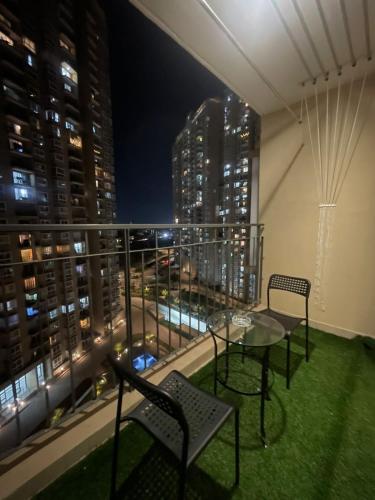 balcón con mesa, sillas y vistas al perfil urbano en Hobbit - A sophisticated 2 bhk In Bharathiya city en Bangalore