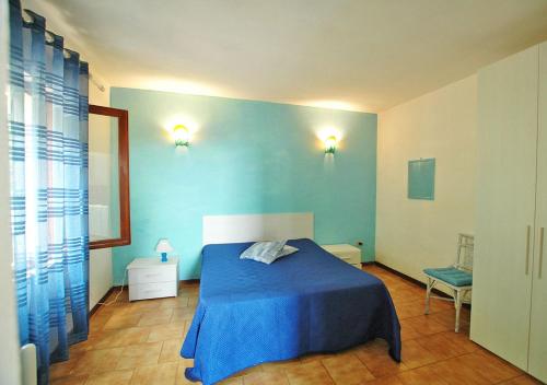 a blue bedroom with a bed and a chair at Arlecchino in Capoliveri