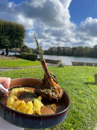 a plate of food with a piece of meat in a bowl at LOGIS Hôtel & Restaurant - Les Bords de Seine in La Roche-Guyon