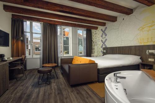 um quarto de hotel com uma cama e uma banheira em Inntel Hotels Amsterdam Centre em Amsterdã