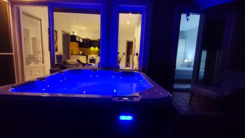 a jacuzzi tub in a living room with blue lighting at Sea La Vie Apt. in Paleokastritsa