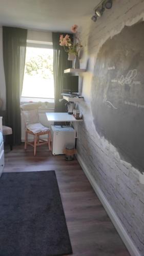 a living room with a brick wall and a desk at Villa Jani b&b in Breitscheid