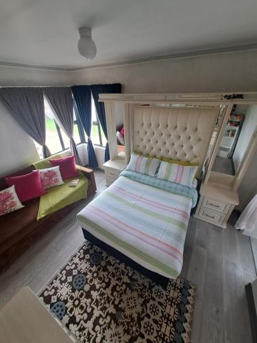 niewielka sypialnia z łóżkiem i kanapą w obiekcie Flora's Garden 
