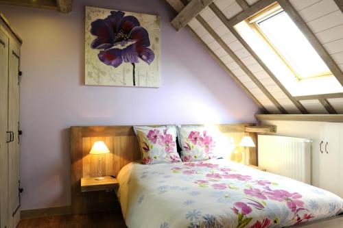 1 dormitorio con 1 cama con colcha de flores en Le pic drille, en Charmont-sous-Barbuise