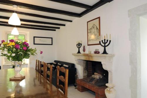 un salon avec une cheminée et un vase de fleurs dans l'établissement La maison de celine, aux Riceys