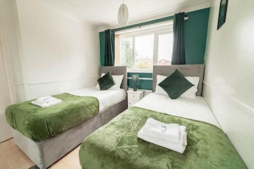 two beds in a room with green and white at Contractors - Family - City Centre - NEC in Birmingham