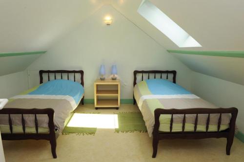 2 Betten in einem Zimmer mit Dachgeschoss in der Unterkunft Le four banal in Bligny