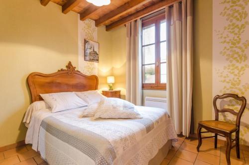 1 dormitorio con 1 cama, 1 silla y 1 ventana en Le bati celher, en Laubressel